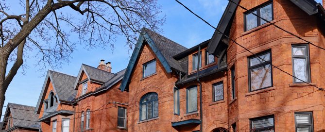 Toronto homes with new roofs. street of large old semi-detached brick houses with gables
